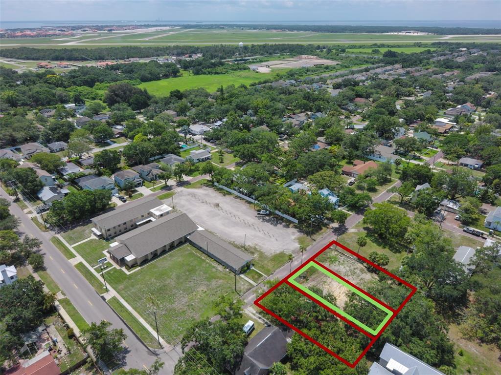 An aerial view shows a vacant lot outlined in red and green near a residential neighborhood — 6907 S SPARKMAN STREET, TAMPA, FL