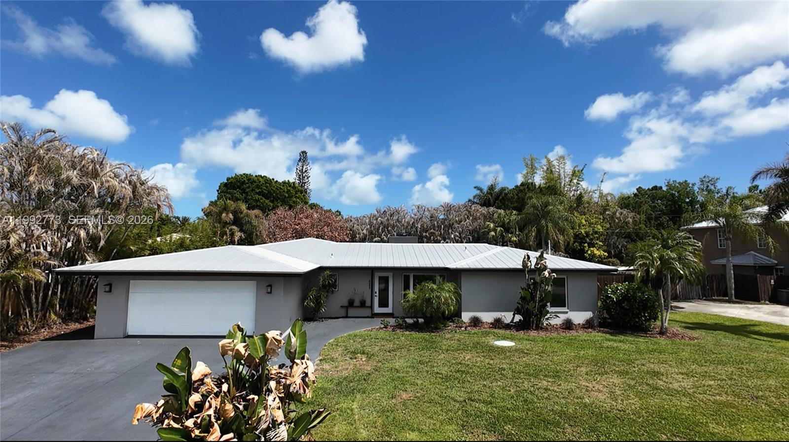 An aerial view shows a single-story house with a metal roof, pool, and driveway — 2497 NW South Manor Ave, Stuart FL 34994, STUART, FL