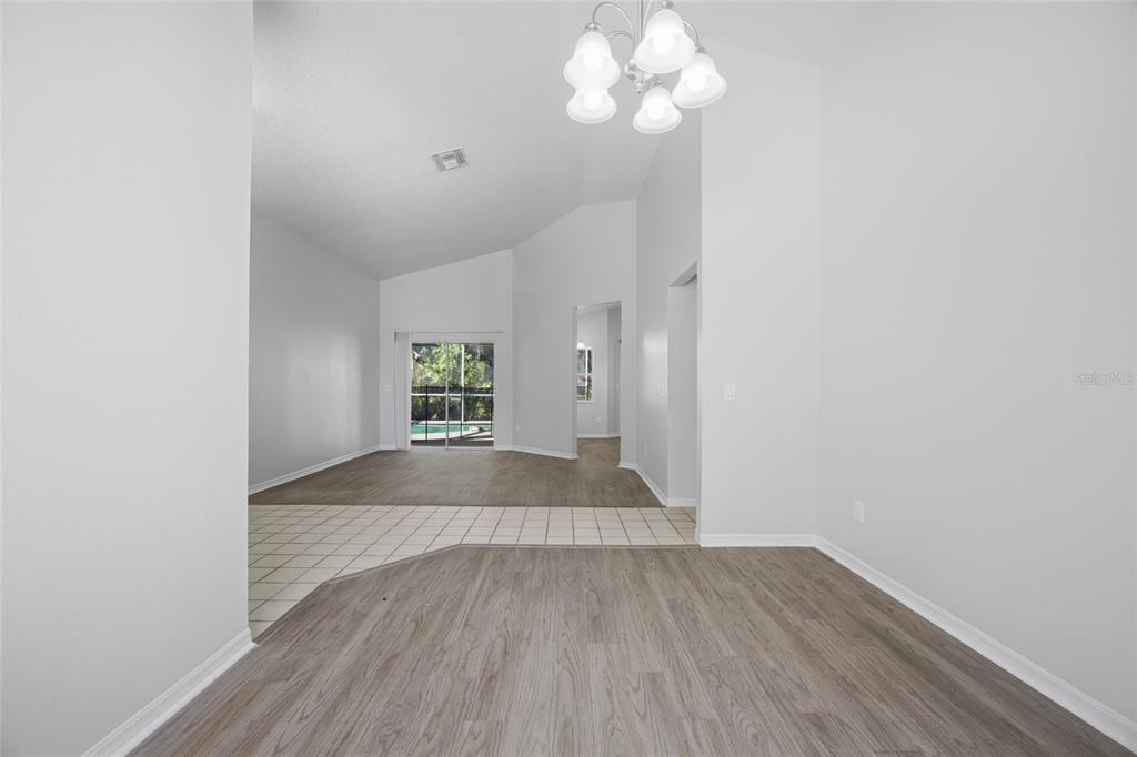 An interior view shows a dining area with wood-look flooring and a tiled transition — 812 CRESTRIDGE DRIVE, TARPON SPRINGS, FL