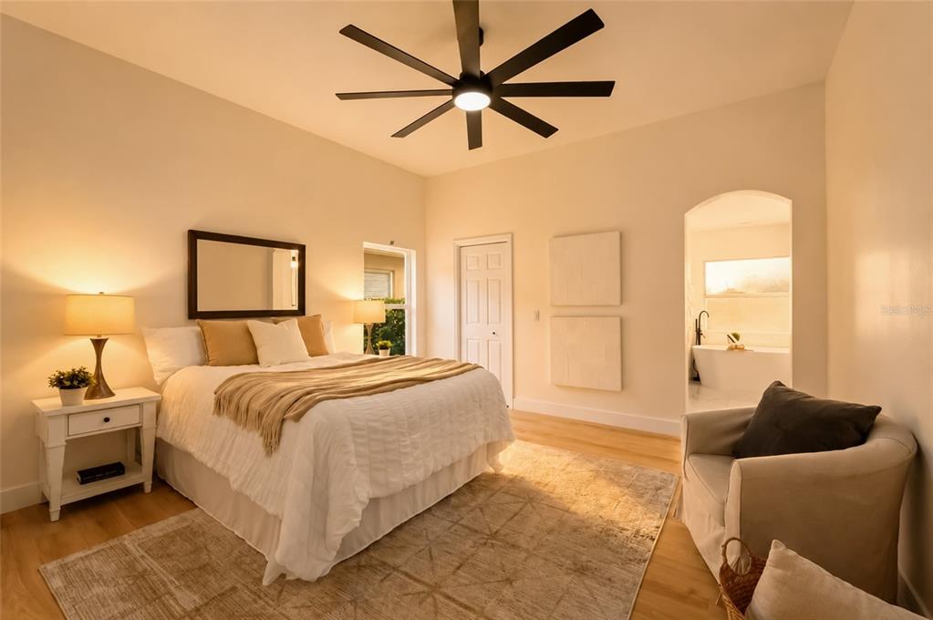 A bedroom with a ceiling fan, a bed, a rug, and an attached bathroom — 10117 WHISPER POINTE DRIVE, TAMPA, FL