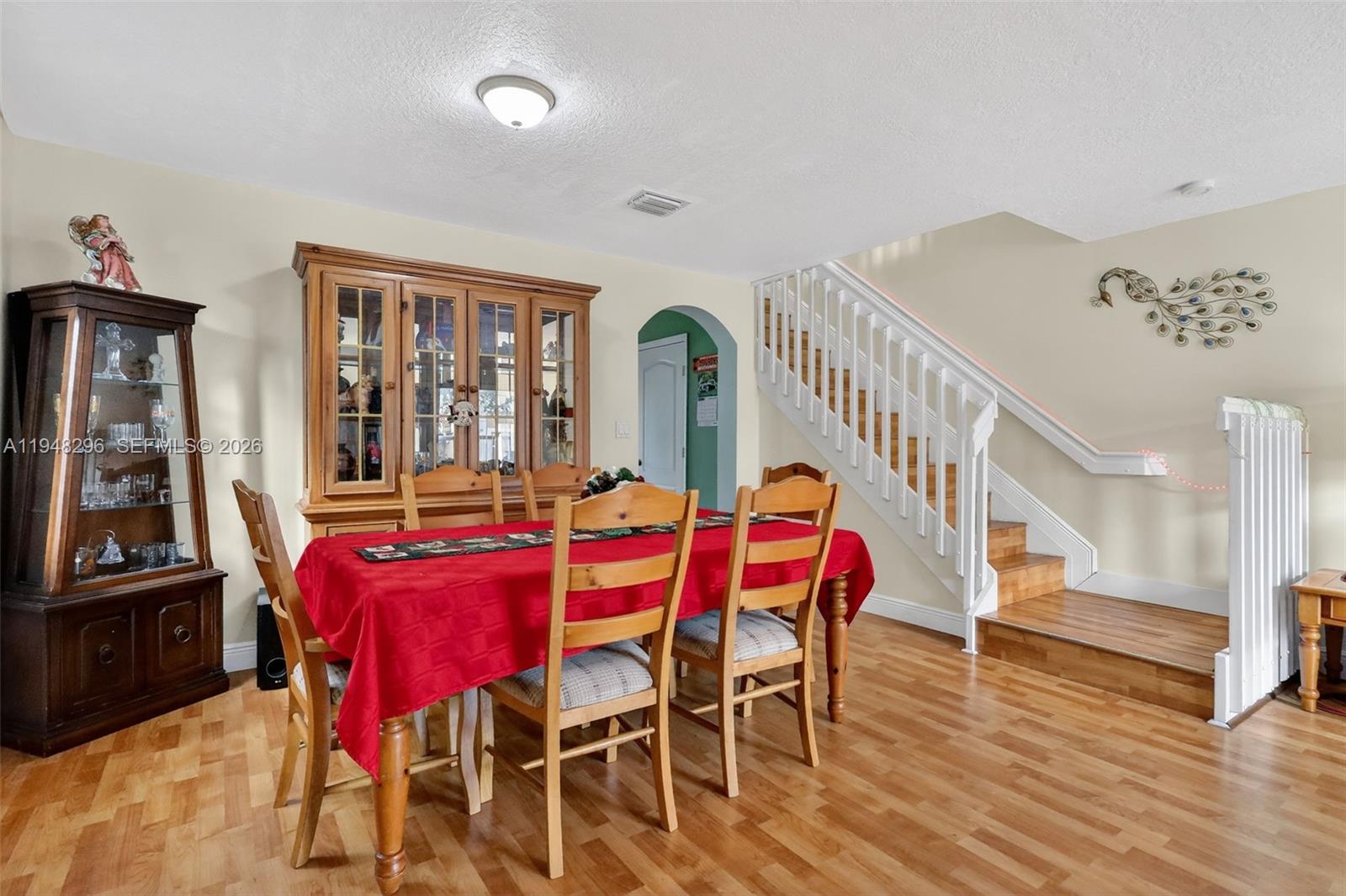 A dining room features a wooden hutch, a red-clothed table, and a staircase — 3160 SW 129th Ter # 118, Miramar FL 33027, MIRAMAR, FL