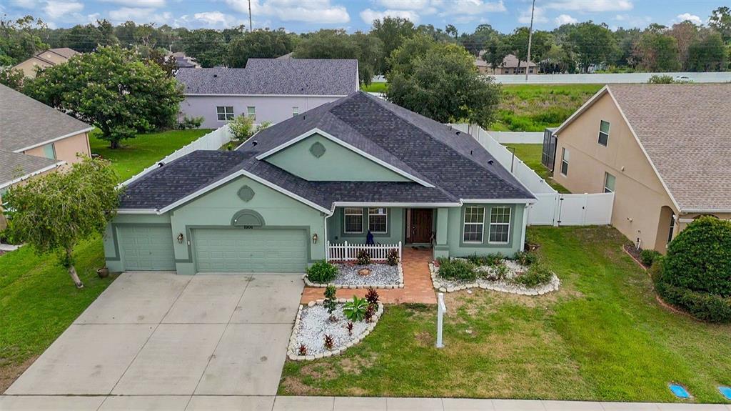 An aerial view of a single-story green house with a two-car garage and shingled roof — 2206 VIA CORTONA STREET, PLANT CITY, FL
