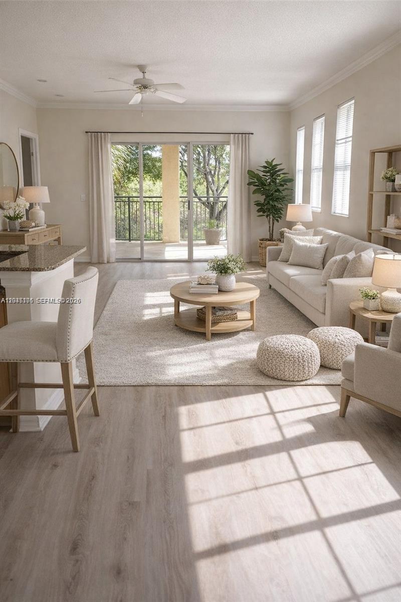 A bright living room features light wood flooring, a neutral sofa, and a balcony view — 2493 Centergate Dr # 204, Miramar FL 33025, MIRAMAR, FL