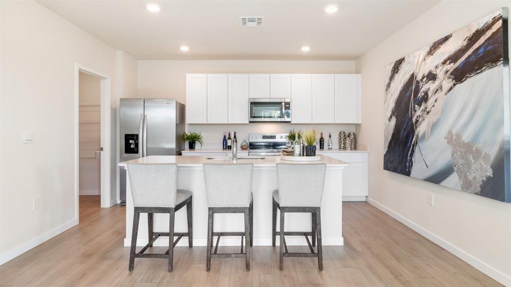 A living room features light-colored sofas, a wooden coffee table, and a television on a console — 7366 SW 45TH COURT, OCALA, FL