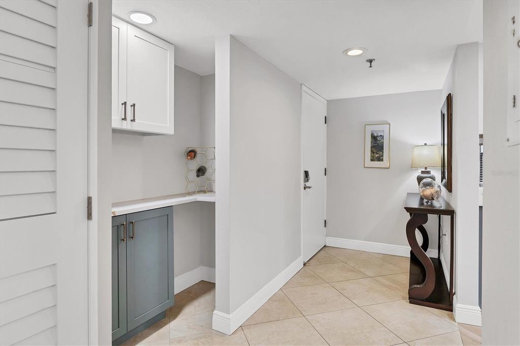 A hallway features tile flooring, a small wet bar area, and a console table — 1001 BENJAMIN FRANKLIN DRIVE UNIT 201, SARASOTA, FL