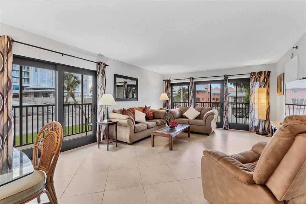 A living room with tile floors, two sofas, a recliner, and glass doors to balconies — 1001 BENJAMIN FRANKLIN DRIVE UNIT 201, SARASOTA, FL