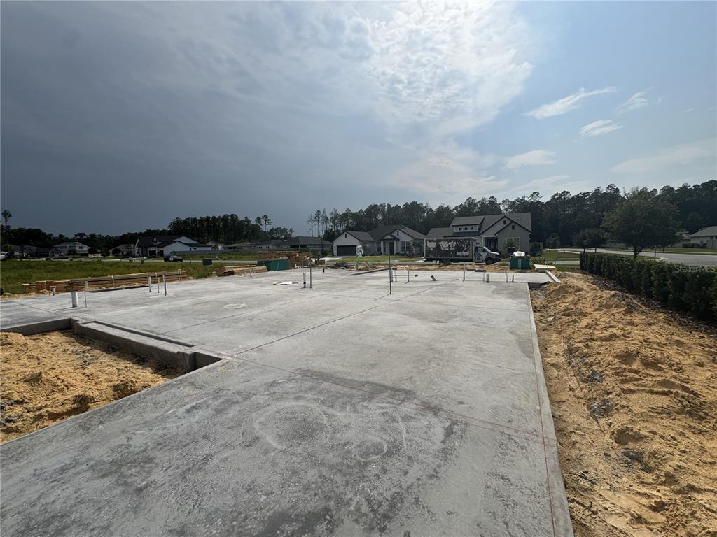 A concrete slab foundation for a new house construction sits on a cleared residential lot — 801 SW 144TH DRIVE, NEWBERRY, FL