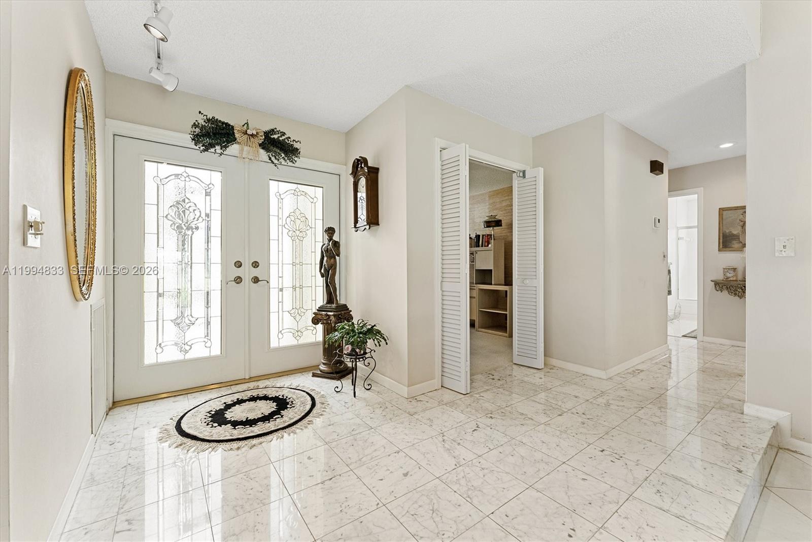 A bright entryway features white marble flooring, double glass-paneled doors, and a statue on a pedestal — 5669 Pinecrest Cir, Boca Raton FL 33433, BOCA RATON, FL