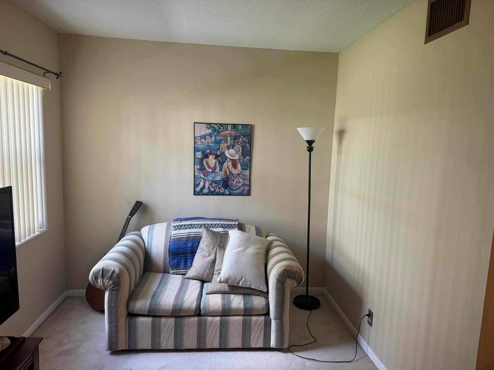 A small living area features a striped loveseat, a floor lamp, and wall art — 5501 NW 2nd Avenue, Boca Raton FL 33487, BOCA RATON, FL