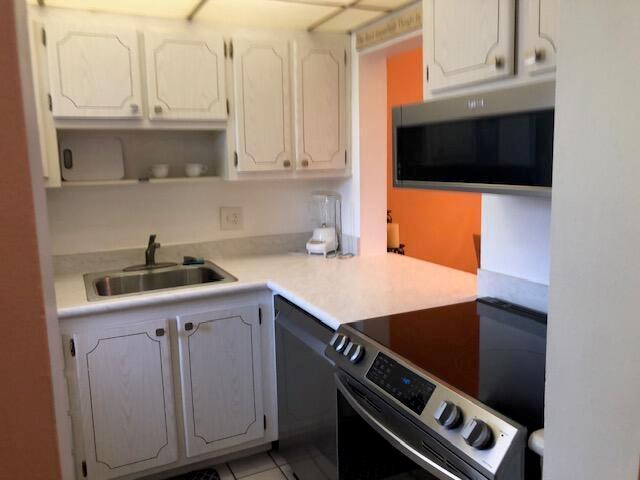 A kitchen with white cabinets, stainless steel appliances, and a stainless steel sink — 5501 NW 2nd Avenue, Boca Raton FL 33487, BOCA RATON, FL