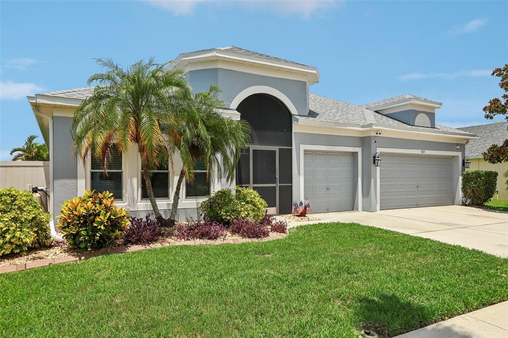 A single-story house with a gray exterior, a screened entryway, and a two-car garage — 809 SEMINOLE SKY DRIVE, RUSKIN, FL