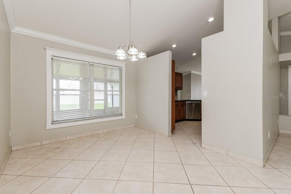 A dining area with a chandelier, tile flooring, and a view into the kitchen — 2708 ASHLEY COURT, KISSIMMEE, FL