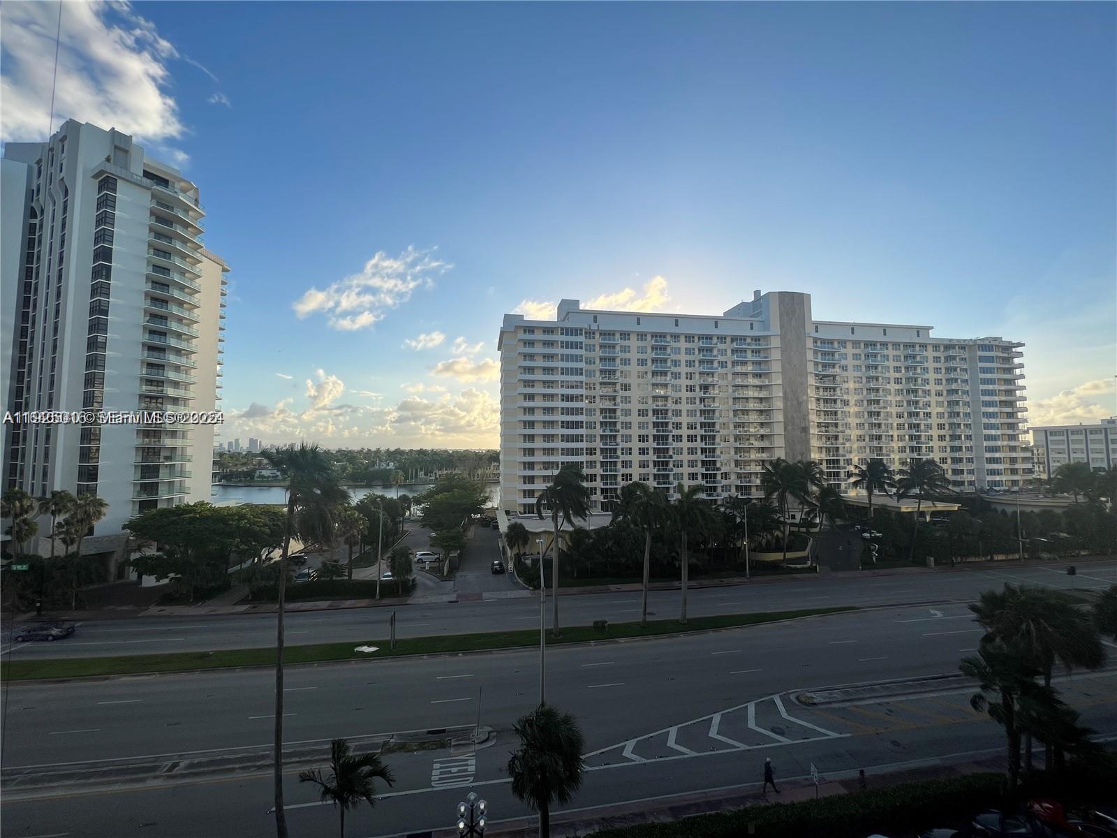 An exterior view shows two tall residential buildings separated by a road and palm trees — 5555 Collins Ave # 7T, Miami Beach FL 33140, MIAMI BEACH, FL