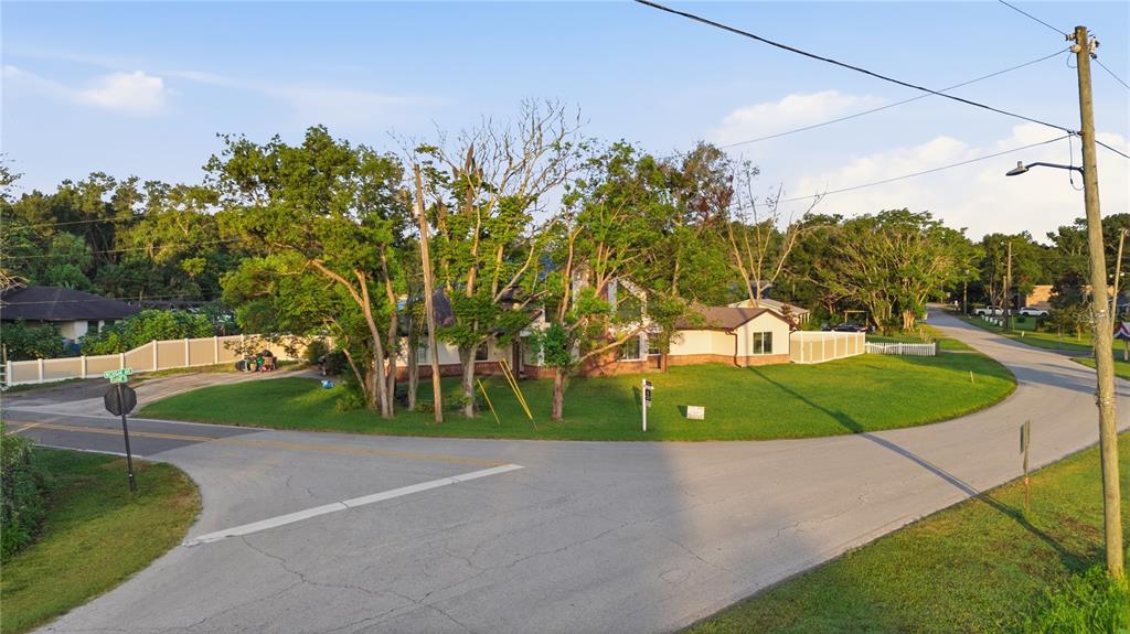 A single-story house with a large lawn sits on a corner lot at a road intersection — 212 PLEASANT STREET, LAKE HELEN, FL