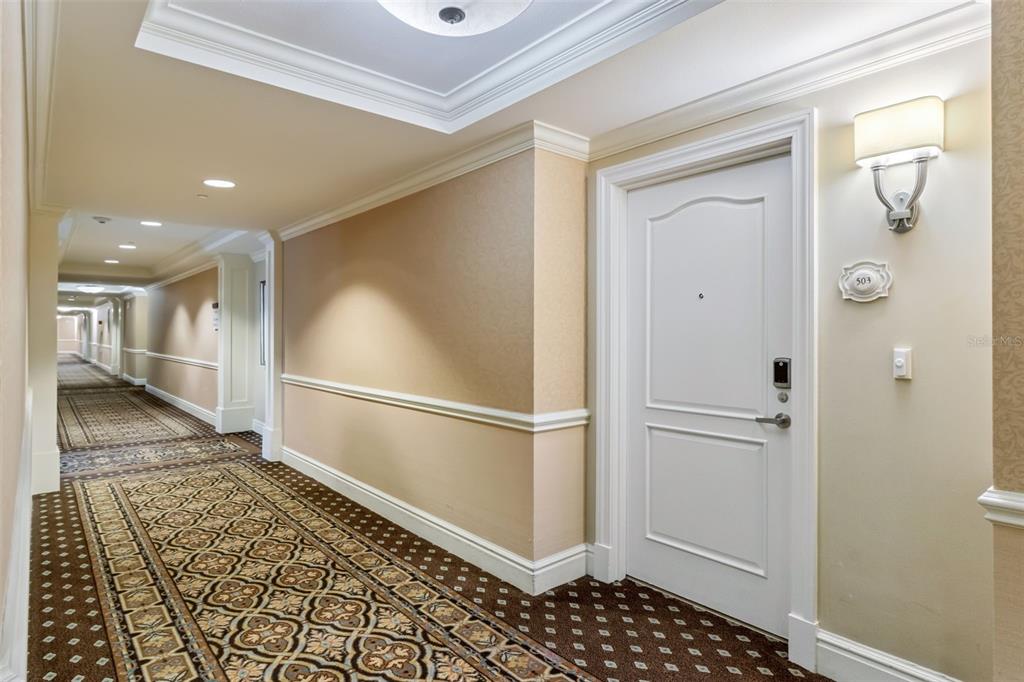 A hotel hallway with patterned carpet, beige walls, and a white door labeled 503 — 7593 GATHERING DRIVE UNIT 503, REUNION, FL