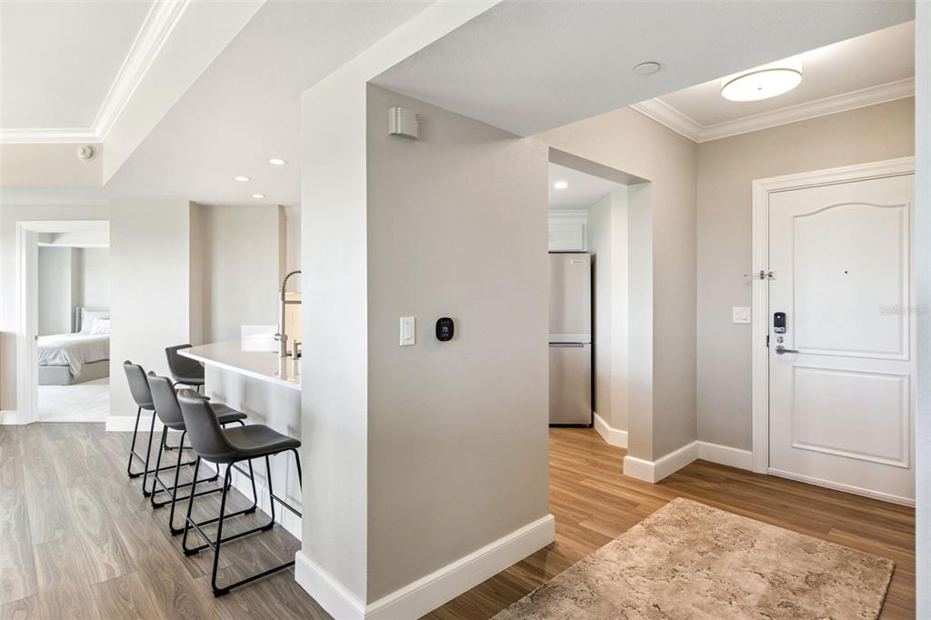 An interior view shows a kitchen breakfast bar, a hallway leading to a refrigerator, and an entryway — 7593 GATHERING DRIVE UNIT 503, REUNION, FL