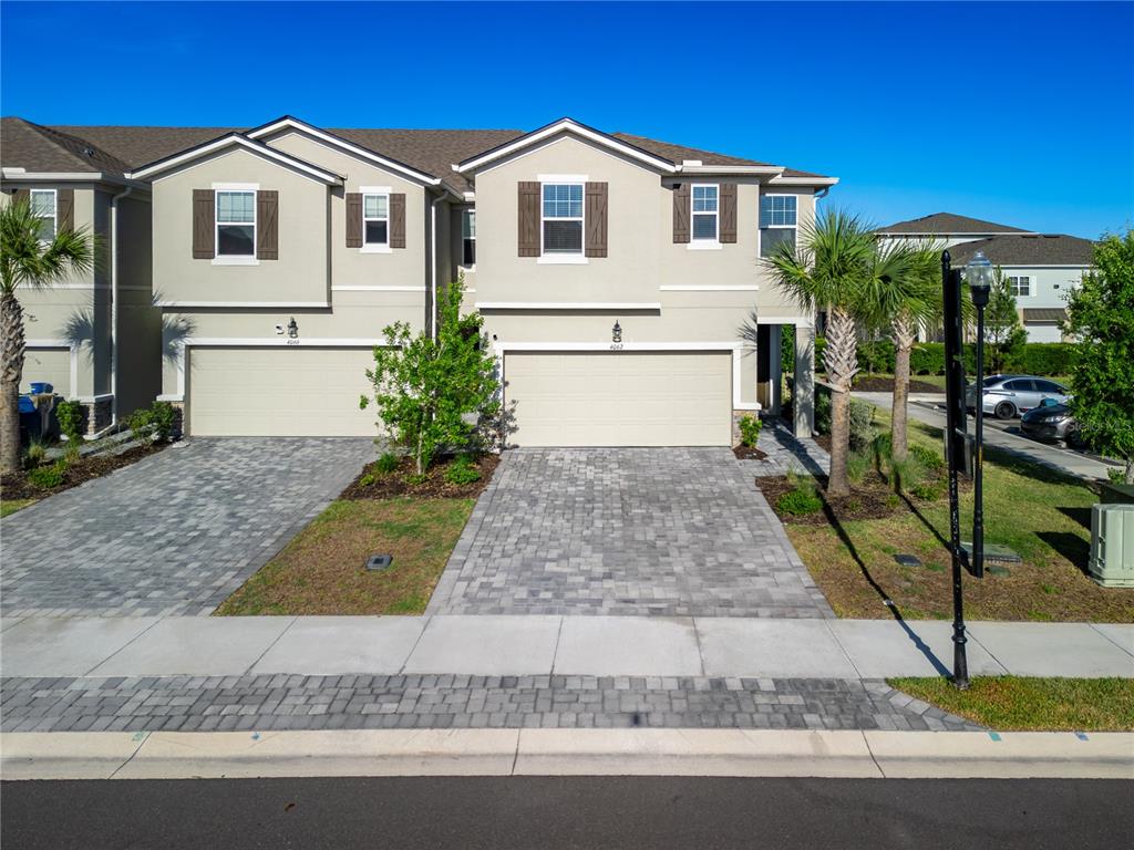 An aerial view shows a community clubhouse with a swimming pool next to a pond — 4062 CLOUD HOPPER WAY, LUTZ, FL
