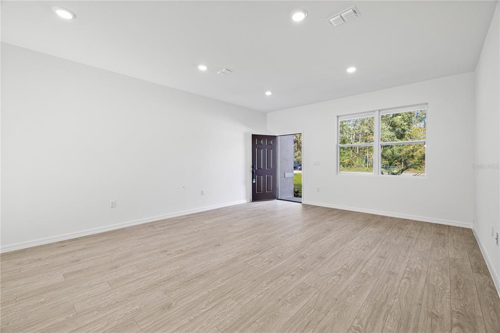 An empty room with light wood-look flooring, white walls, recessed lighting, and an open door — 254 W BRIMSON PLACE, CITRUS SPRINGS, FL