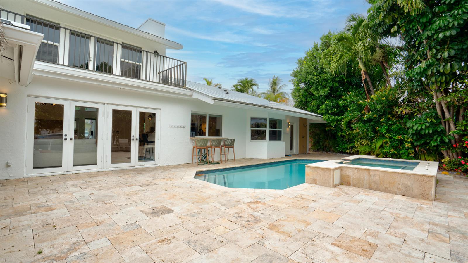 A white house with a pool, hot tub, and stone patio in a backyard setting — 1511 SE 12th Court, Deerfield Beach FL 33441, DEERFIELD BEACH, FL