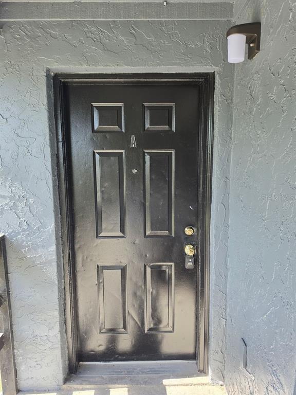 A black front door with a silver letter A and a lockbox on the handle — 2526 S OAK AVENUE UNIT A, SANFORD, FL