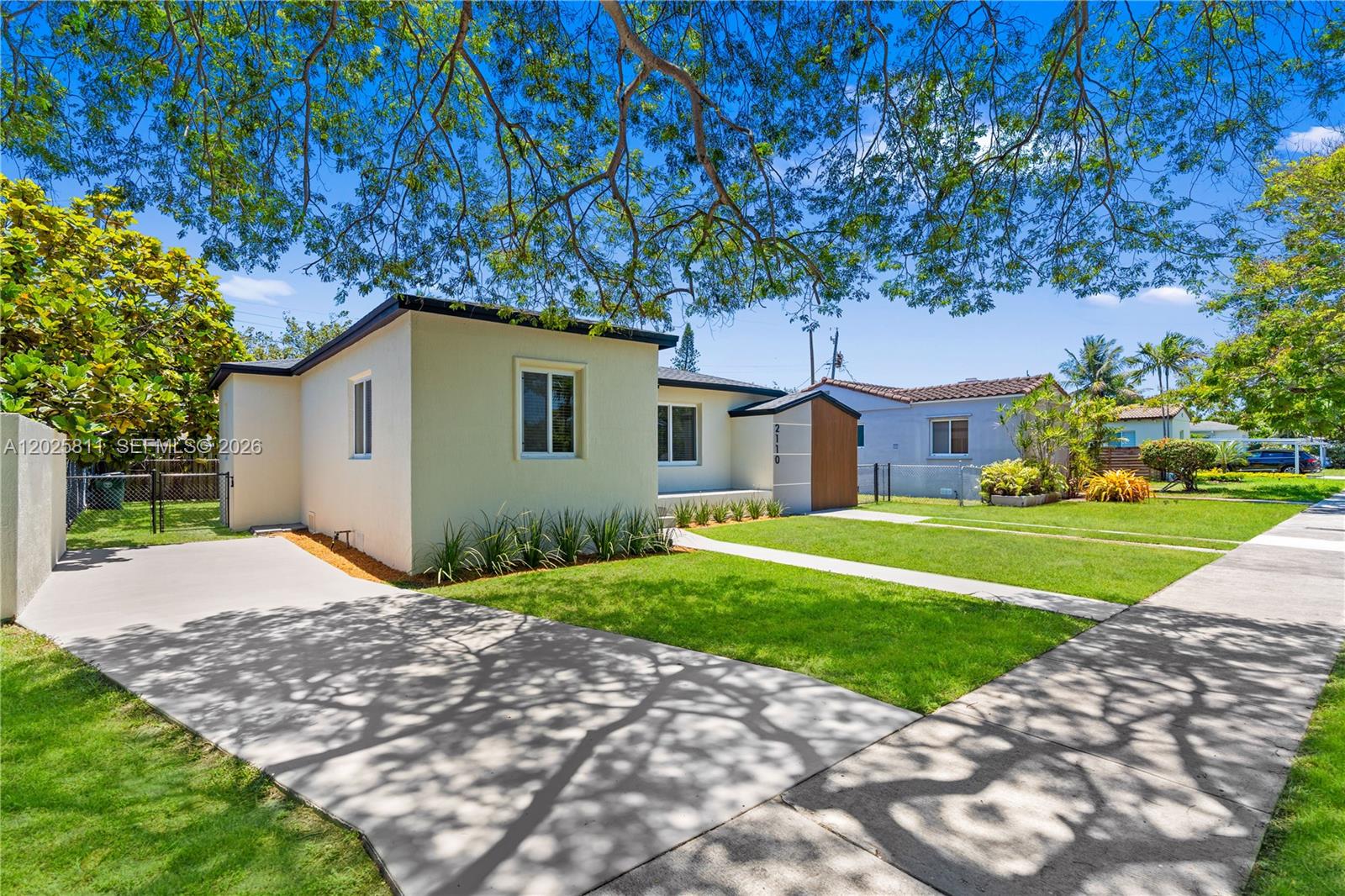 A single-story house with a light-colored exterior, a concrete driveway, and a front lawn — 2110 SW 15th St, Miami FL 33145, MIAMI, FL