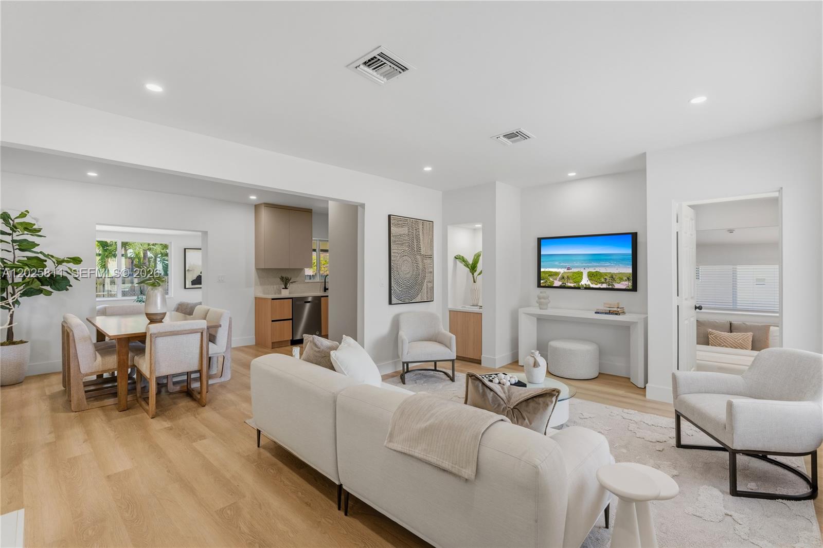 A bright, open-concept living and dining area features light wood floors and neutral furniture — 2110 SW 15th St, Miami FL 33145, MIAMI, FL