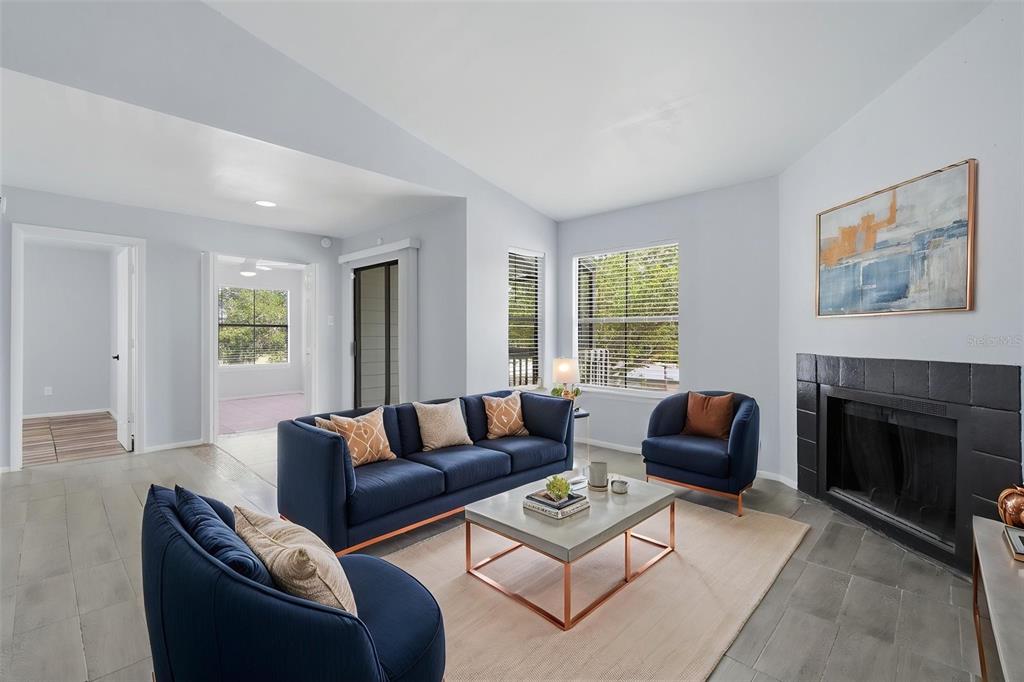 A living room features a blue sofa, two armchairs, a coffee table, and a fireplace — 3716 IDLEBROOK CIRCLE UNIT 212, CASSELBERRY, FL