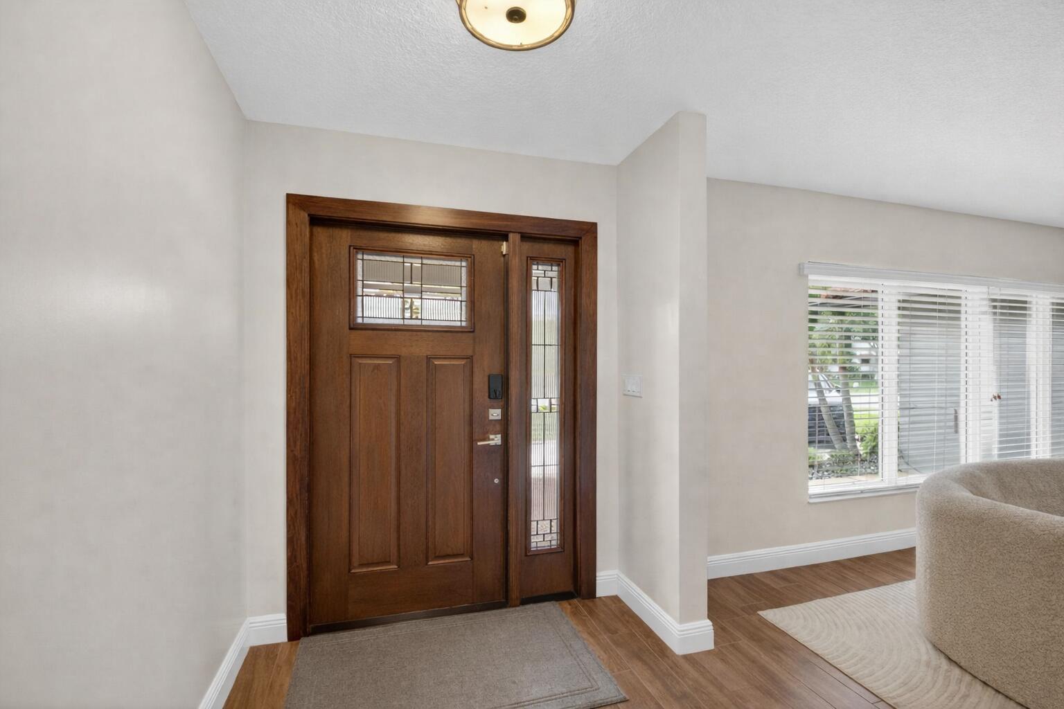 An entryway features a dark wood front door with a sidelight and wood-look tile flooring — 650 SW 16th Street, Boca Raton FL 33486, BOCA RATON, FL