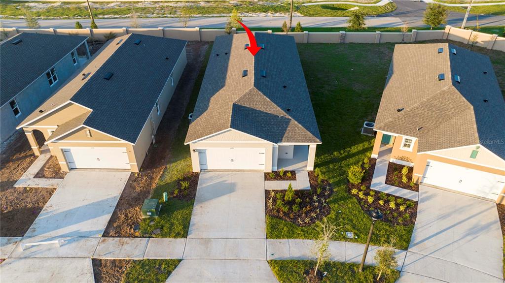 An aerial view shows three suburban houses with gray roofs and concrete driveways — 1779 POST OAK DRIVE, DAVENPORT, FL