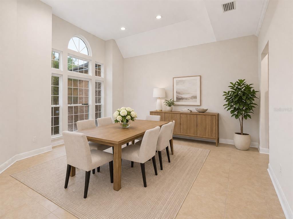 A dining room with a wooden table, six chairs, a sideboard, and large arched windows — 8600 SW 103RD AVENUE, GAINESVILLE, FL