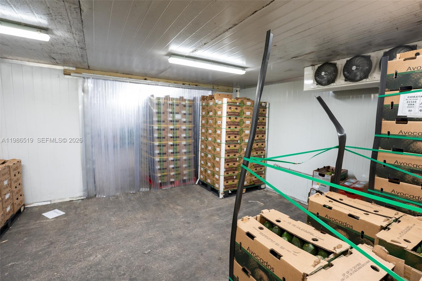 A refrigerated storage room contains stacks of cardboard boxes filled with avocados — 1227 NW 21st Street, FL 33142, FL