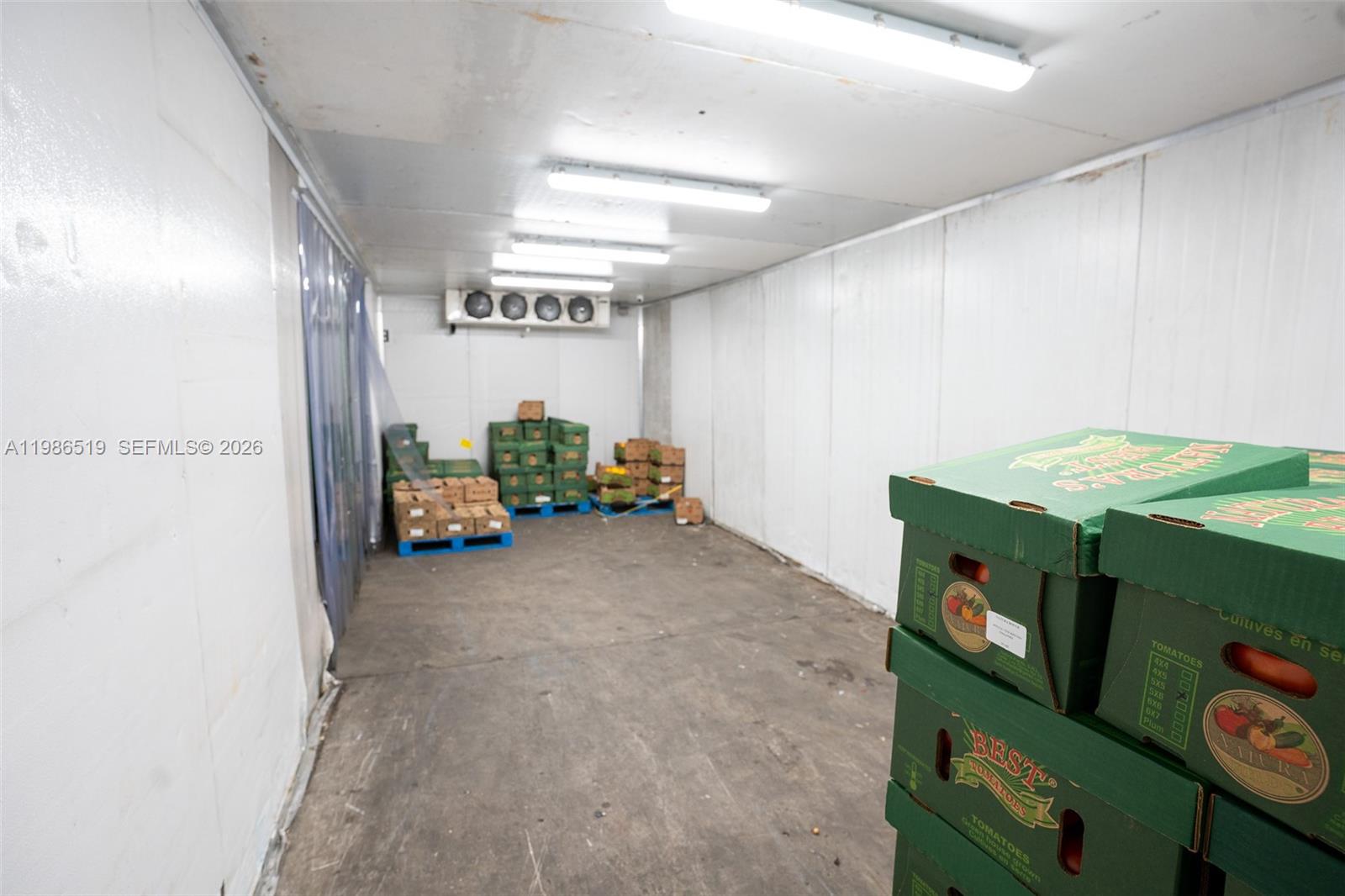 A walk-in cooler contains stacks of produce boxes on pallets against the back wall — 1227 NW 21st Street, FL 33142, FL