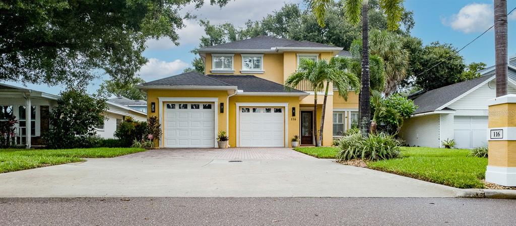 A two-story yellow house with a two-car garage and a concrete driveway — 116 S HESPERIDES STREET, TAMPA, FL