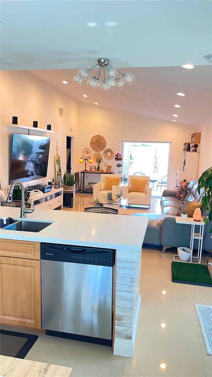 A kitchen island with a stainless steel dishwasher overlooks an open-concept living room — 1359 Summit Run Cir, West Palm Beach FL 33415, WEST PALM BEACH, FL