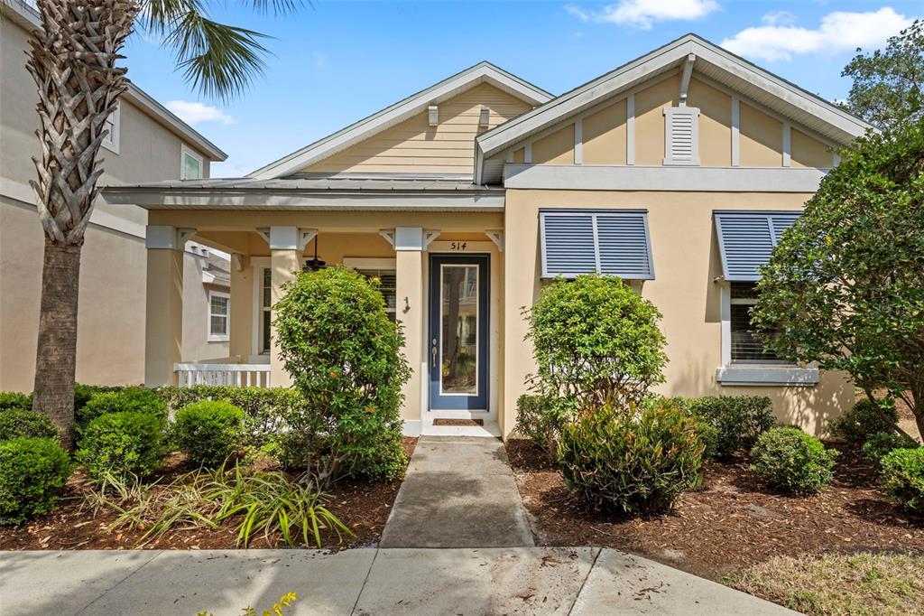 A single-story house with a beige exterior, blue door, front porch, and landscaped yard — 514 WINTERSIDE DRIVE, APOLLO BEACH, FL