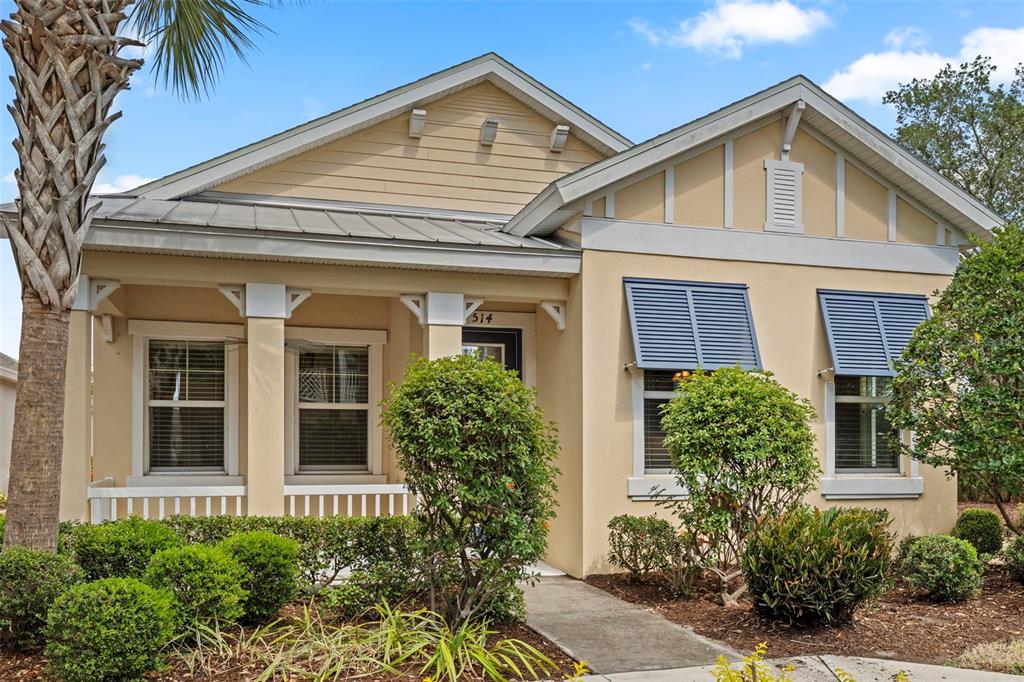 A single-story house with a covered front porch, beige siding, and blue window shutters — 514 WINTERSIDE DRIVE, APOLLO BEACH, FL
