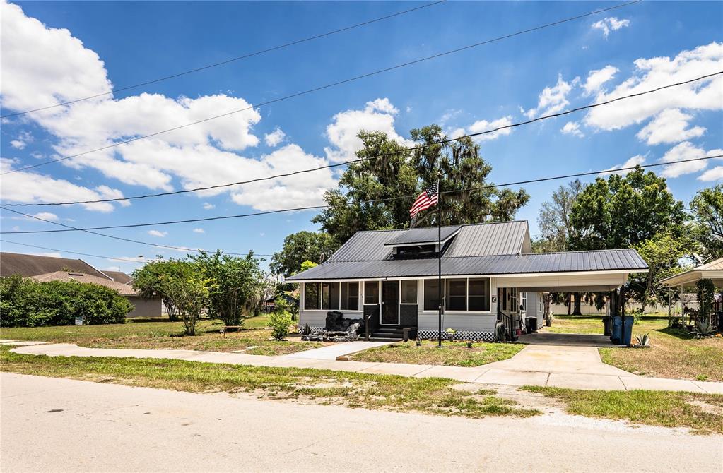 A single-story house with a metal roof, a front porch, and an attached carport — 113 SE PINE AVENUE, FORT MEADE, FL