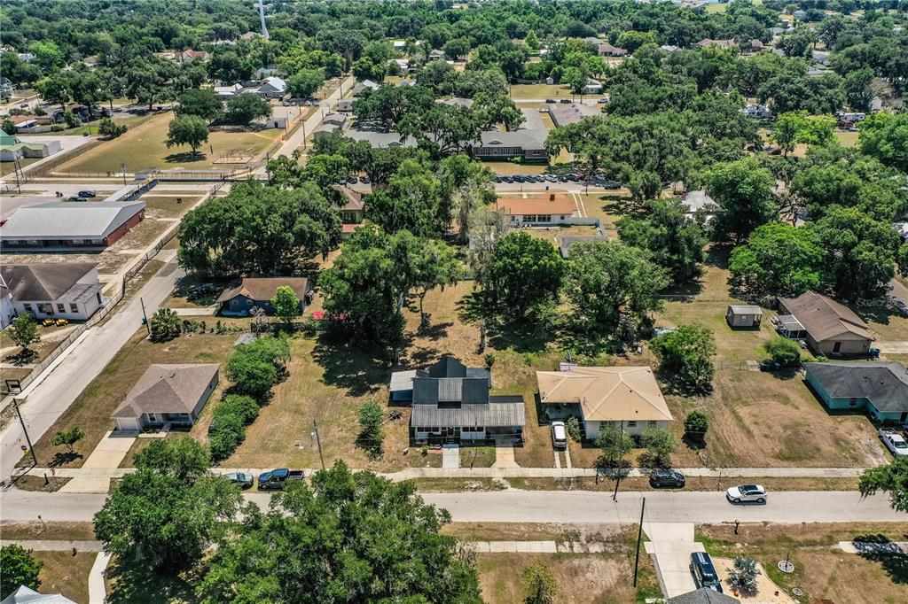 An aerial view shows several residential houses surrounded by trees and grassy lots — 113 SE PINE AVENUE, FORT MEADE, FL
