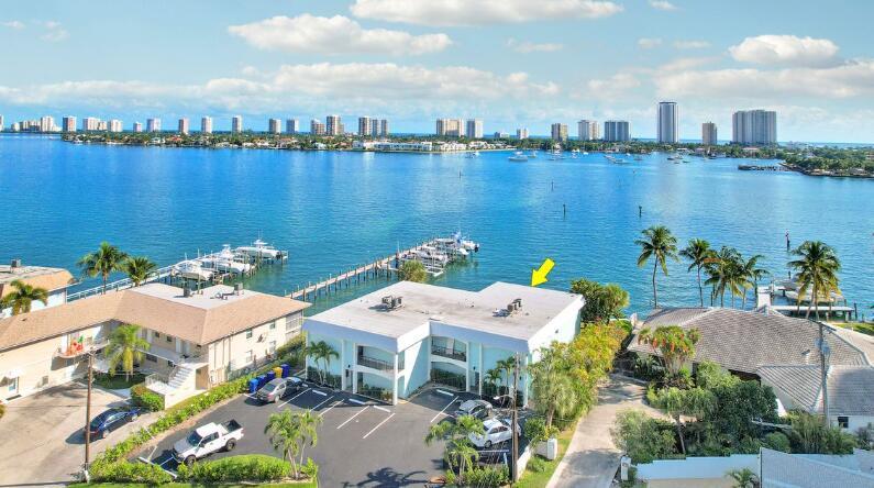 An aerial view shows a light blue two-story apartment building next to a waterfront dock — 360 Wilma Circle # 5, Riviera Beach FL 33404, RIVIERA BEACH, FL