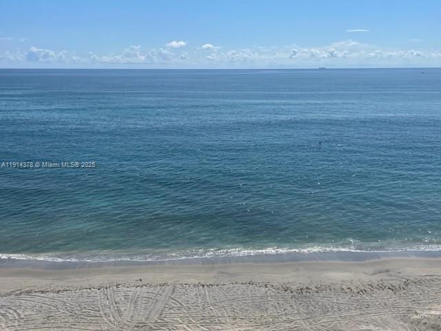 An elevated view of a sandy beach meeting the blue ocean under a clear sky — 19670 Beach Rd, Tequesta FL 33469, TEQUESTA, FL