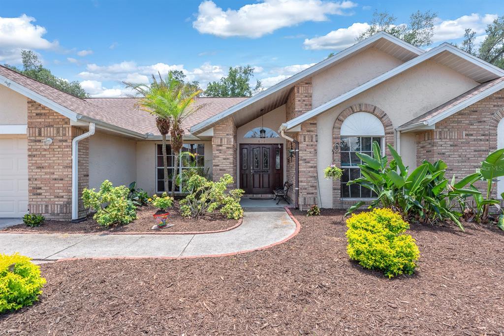 A single-story house with a brick and stucco exterior, a front walkway, and landscaped yard — 621 PENN NATIONAL ROAD, SEFFNER, FL
