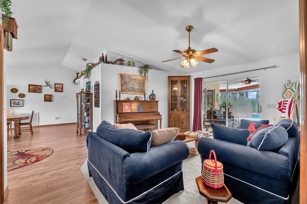 A living room features dark blue sofas, a piano, and a sliding door to a patio — 621 PENN NATIONAL ROAD, SEFFNER, FL