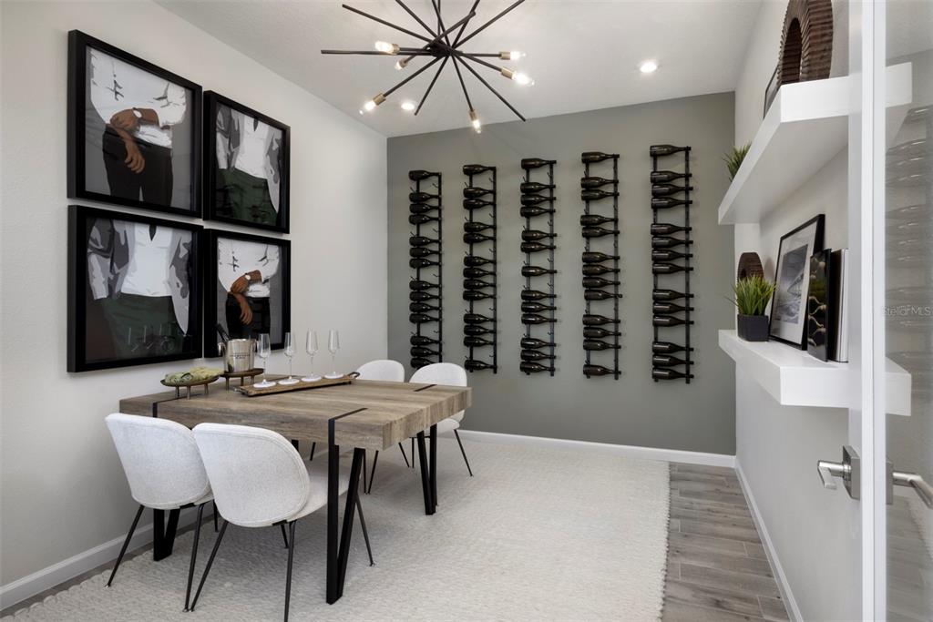 A dining room features a wooden table, white chairs, wall-mounted wine racks, and framed artwork — 18476 GREEN GARDEN COURT, VENICE, FL