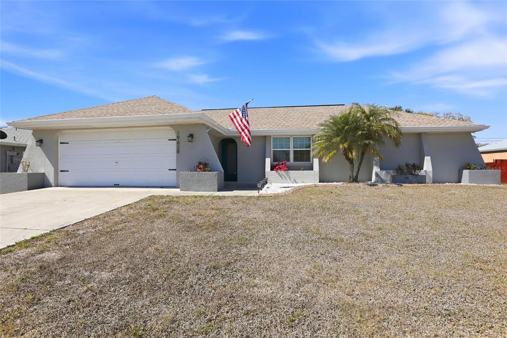 A single-story house with a gray exterior, a two-car garage, and a palm tree — 19628 MIDWAY BOULEVARD, PORT CHARLOTTE, FL