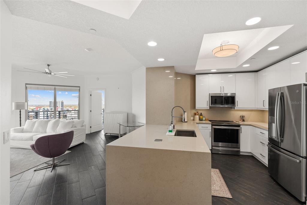 A modern kitchen with a large island overlooks a living area with a city view — 1209 E CUMBERLAND AVENUE UNIT 2103, TAMPA, FL