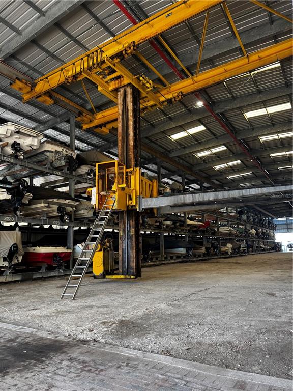 A large indoor boat storage facility features a yellow industrial crane and stacked watercraft — 408 GULF OF MEXICO DRIVE UNIT 1332, LONGBOAT KEY, FL