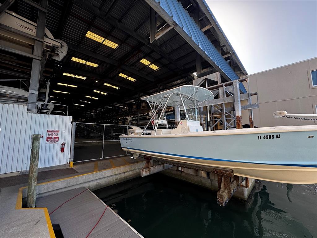 A light blue center console boat sits on a lift at a marina storage facility — 408 GULF OF MEXICO DRIVE UNIT 1332, LONGBOAT KEY, FL