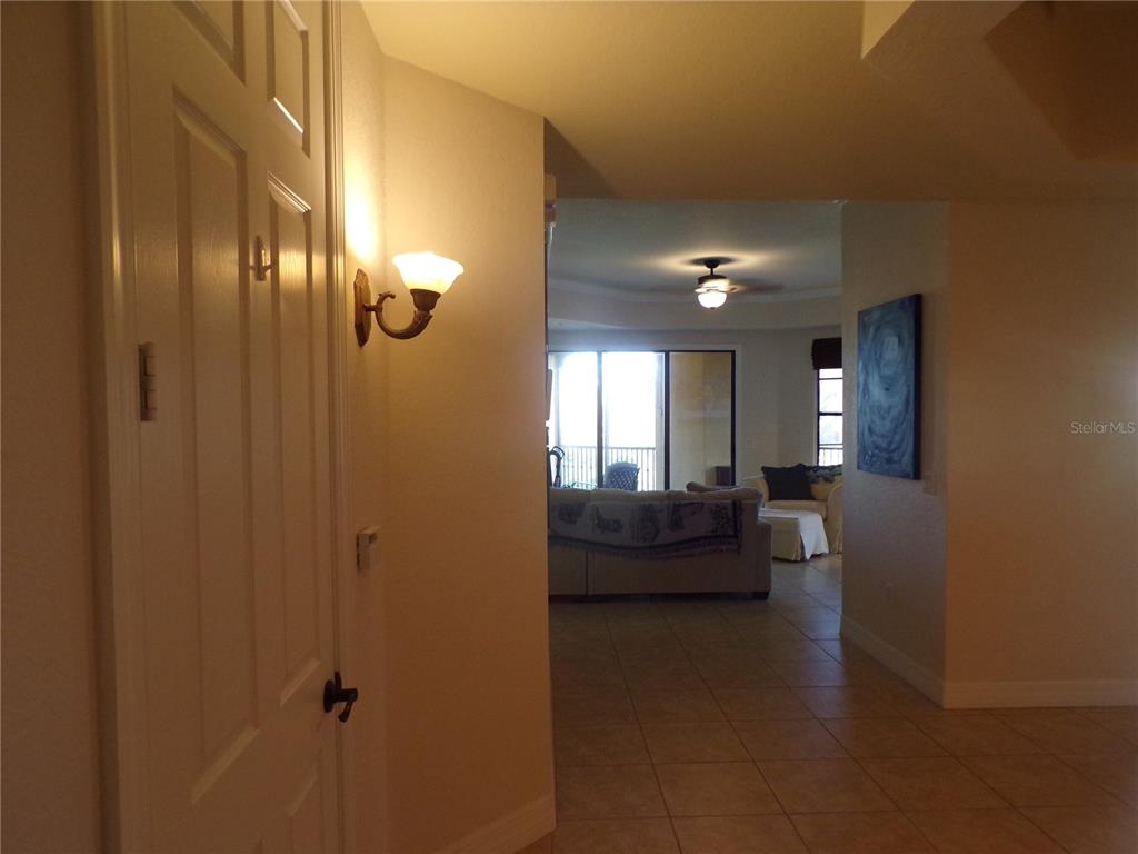 A view from a hallway looking into a living room with tile flooring — 94 VIVANTE BOULEVARD UNIT 302/9432, PUNTA GORDA, FL