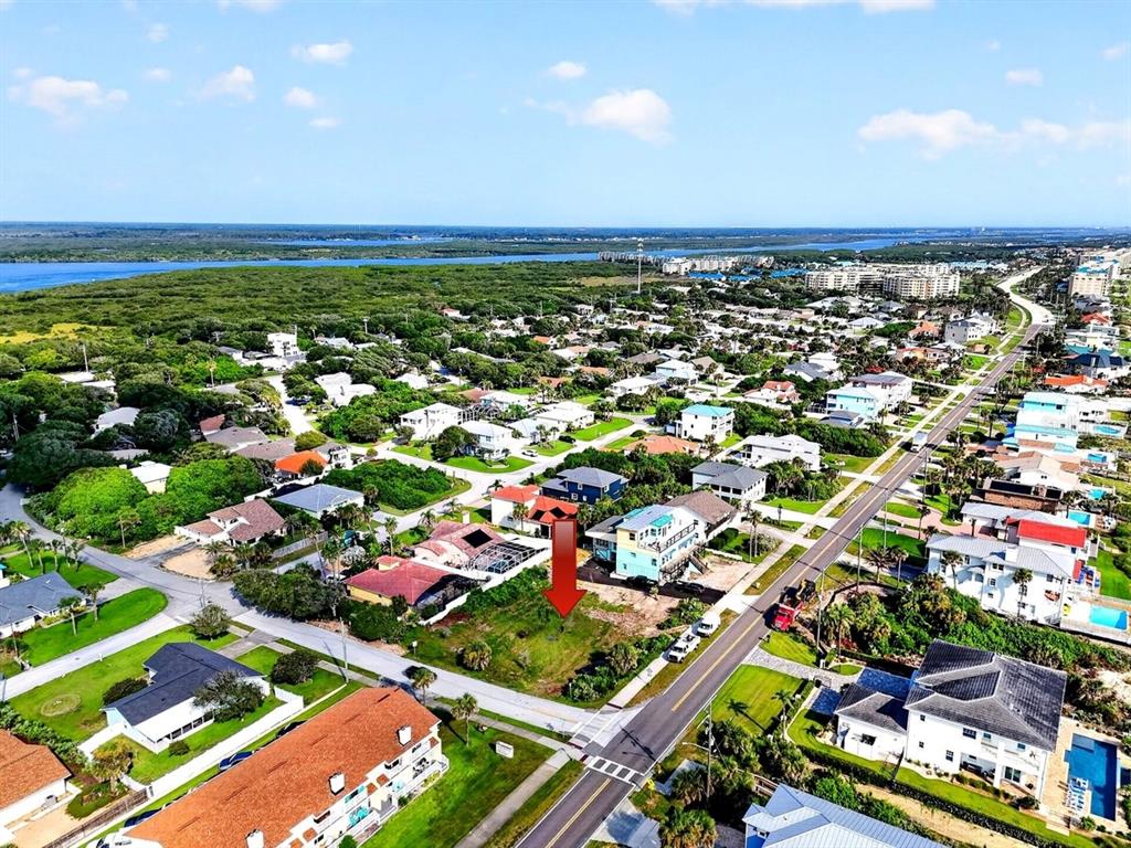 A grassy vacant lot sits next to a house with palm trees in the background — 4738 S ATLANTIC AVENUE, PONCE INLET, FL