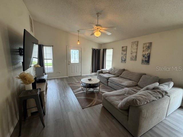 A living room features a large sectional sofa, a coffee table, and a wall-mounted television — 8079 GRAND PINES BOULEVARD, LAKELAND, FL